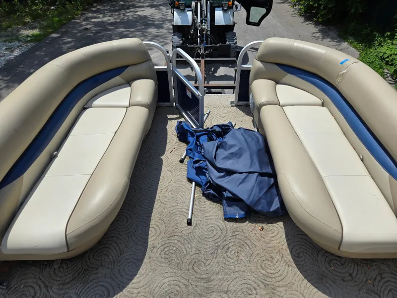 Slide: The Image of 2013 Sun Tracker Party Barge 18 DLX interior with beige seating and blue cover. - 18
