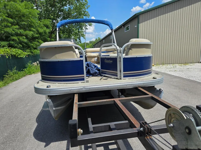 Slide: The Image of 2013 Sun Tracker Party Barge 18 DLX on trailer, parked outdoors near a building. - 6