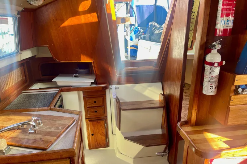 Slide: The Image of Interior of a 1995 Newport 326 sailboat with wooden cabinetry and compact galley area. - 23