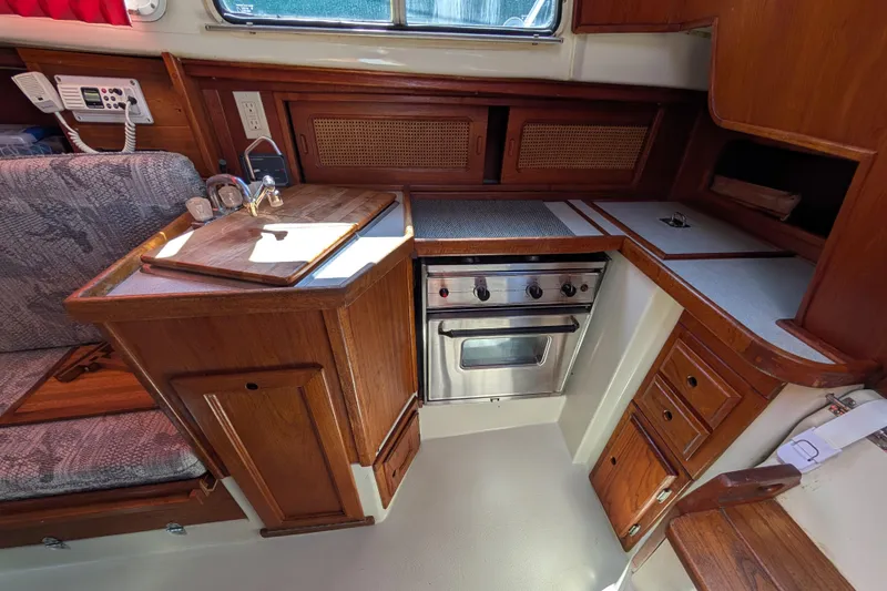 Slide: The Image of Compact 1995 Newport 326 boat galley with wooden cabinetry and stainless steel oven. - 24