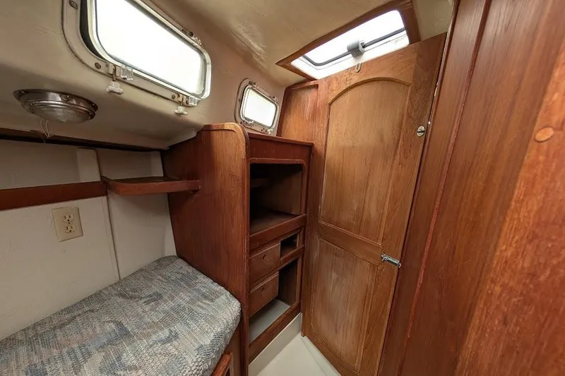 Slide: The Image of Interior of a 1995 Newport 326 sailboat cabin with wooden furnishings and storage. - 28