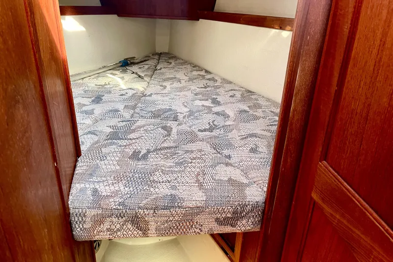 Slide: The Image of Cozy cabin bed in 1995 Newport 326 boat with patterned mattress and wooden interior. - 29