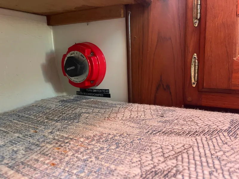 Slide: The Image of Red Perko switch in a Newport 326, 1995 model, near wooden cabinet. - 30