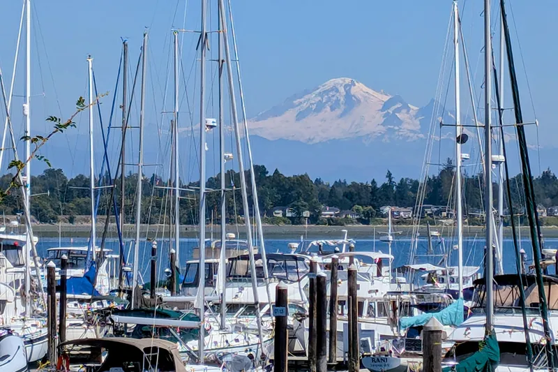 Slide: The Image of Boats docked at a marina with a snow-capped mountain in the background, Newport 326, 1995. - 35