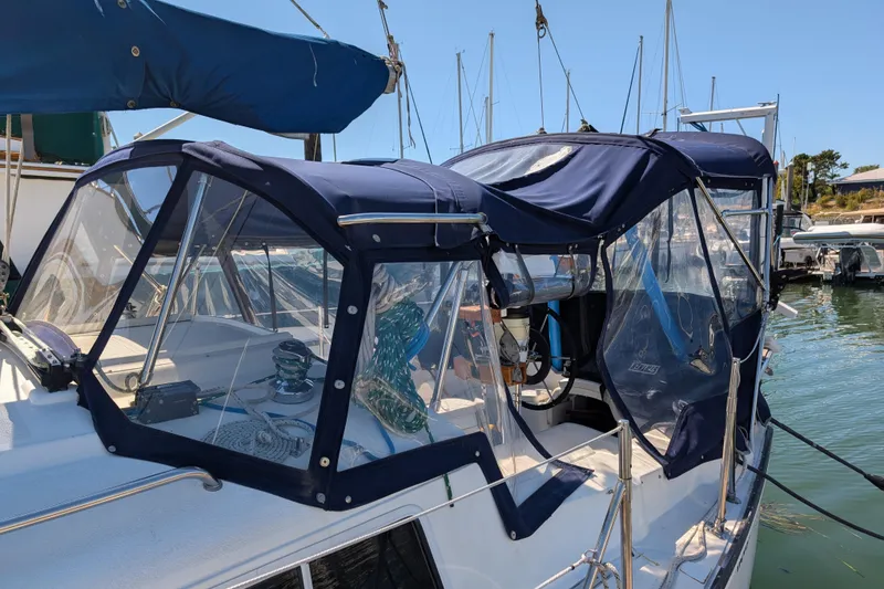 Slide: The Image of 1995 Newport 326 sailboat with blue canopy docked in marina. - 4