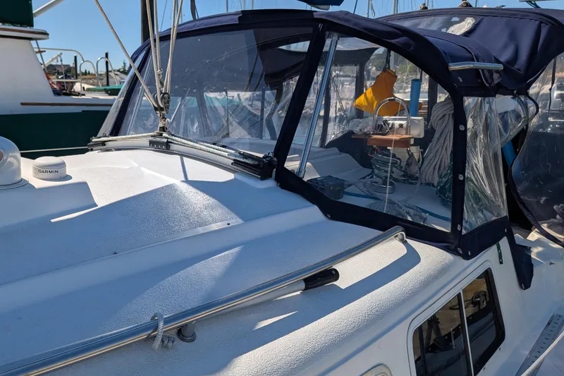 Slide: The Image of 1995 Newport 326 sailboat with cockpit enclosure and Garmin equipment in a marina. - 7