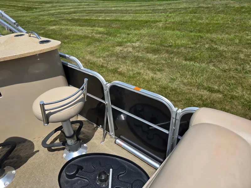 Slide: The Image of 2014 South Bay 522 E boat interior with seating and table, set against grassy background. - 13