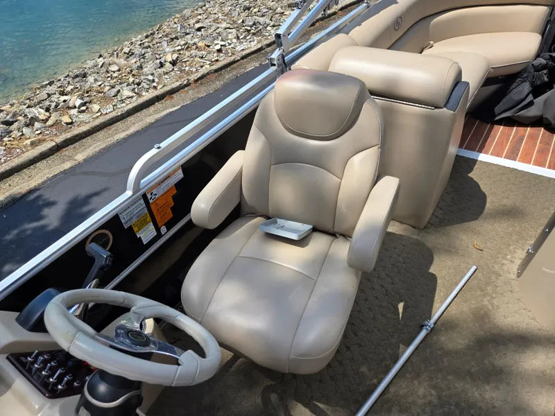 Slide: The Image of Captain's seat on a 2014 South Bay 522 E pontoon boat by the water. - 15