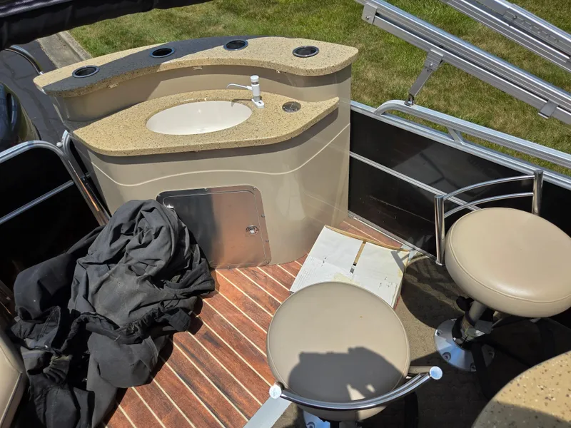 Slide: The Image of 2014 South Bay 522 E boat interior with sink, bar stools, and wooden flooring. - 17