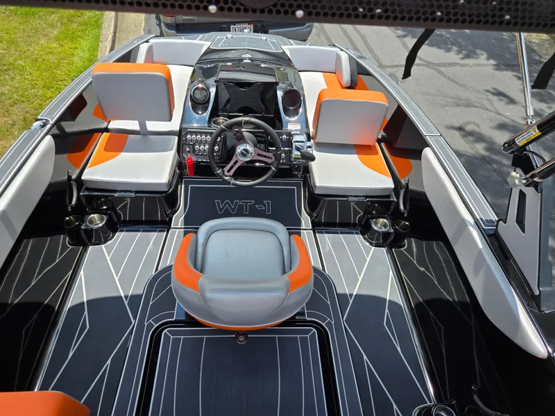 Slide: The Image of 2016 Heyday WT-1 boat interior with orange and gray seating, modern dashboard, and steering wheel. - 10