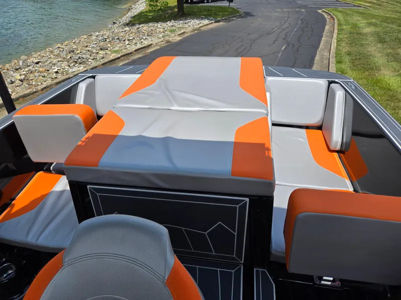 Slide: The Image of 2016 Heyday WT-1 boat interior with orange and gray seating near a lakeside. - 17