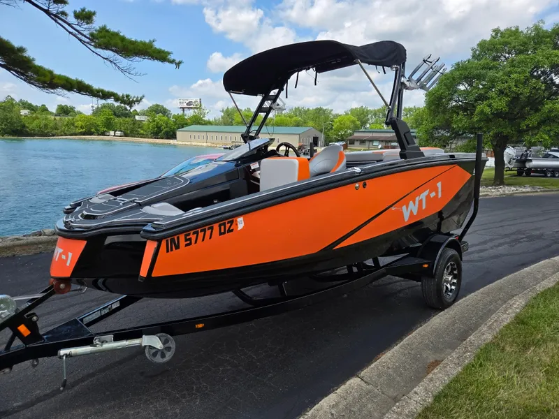 Slide: The Image of 2016 Heyday WT-1 boat on trailer by a lake, featuring vibrant orange and black design. - 7