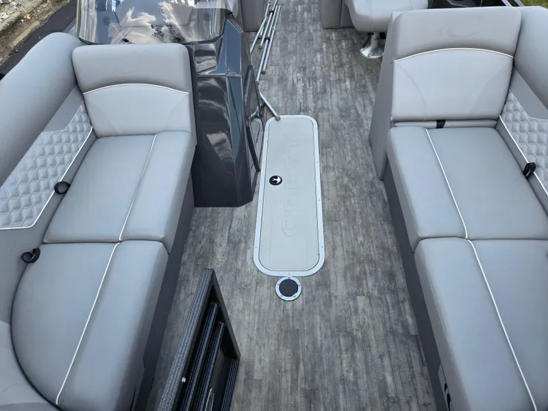 Slide: The Image of 2022 Crest Classic DLX 220 boat interior with gray seating and wood-style flooring. - 11
