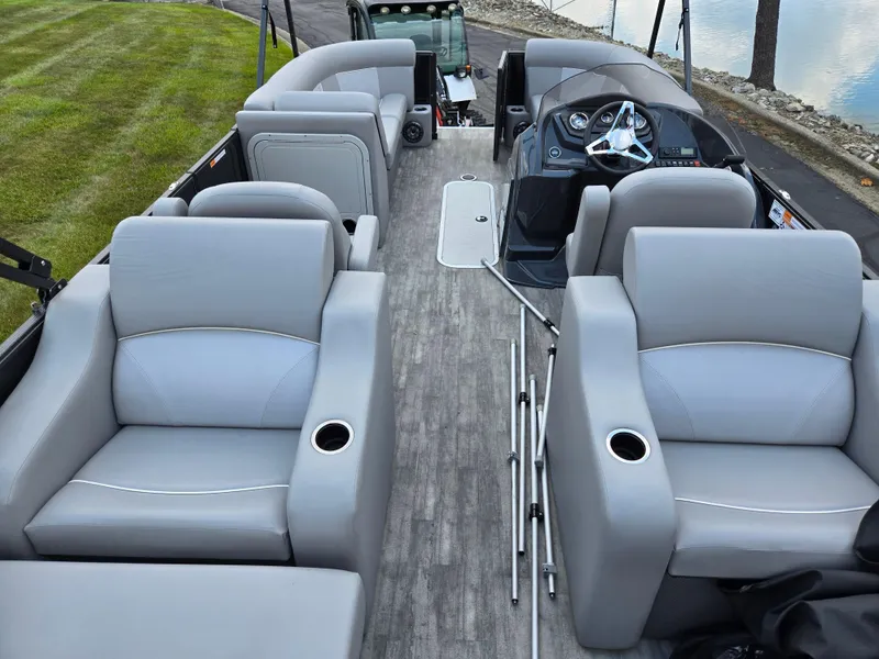 Slide: The Image of 2022 Crest Classic DLX 220 pontoon boat interior with gray seating and steering console. - 18