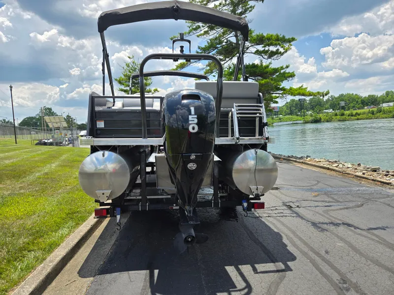Slide: The Image of 2022 Crest Classic DLX 220 pontoon boat with 150 HP engine, parked by a lakeside. - 2