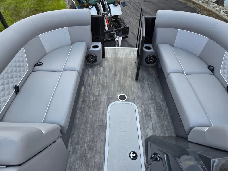 Slide: The Image of 2022 Crest Classic DLX 220 pontoon boat interior with gray seating and flooring. - 22