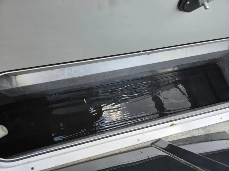 Slide: The Image of Storage compartment with water inside a 2022 Crest Classic DLX 220 boat. - 23