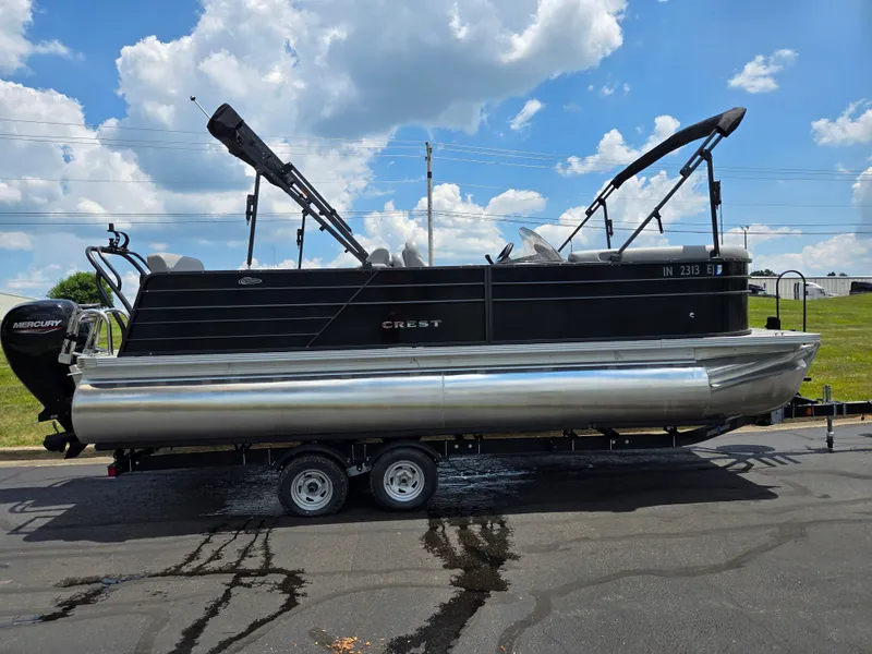 Slide: The Image of 2022 Crest Classic DLX 220 pontoon boat on trailer under blue sky. - 5