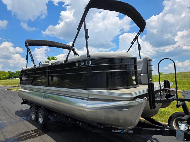 Slide: The Image of 2022 Crest Classic DLX 220 pontoon boat on trailer under blue sky. - 6