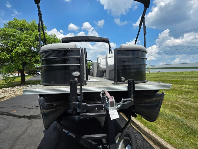 Slide: The Image of 2022 Crest Classic DLX 220 pontoon boat on trailer, parked outdoors under blue sky. - 7