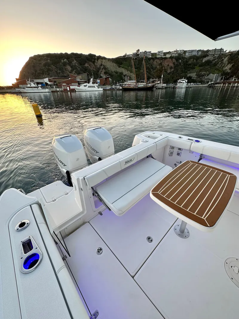 Slide: The Image of 2014 Boston Whaler 315 Conquest boat at sunset, docked in a scenic harbor. - 16