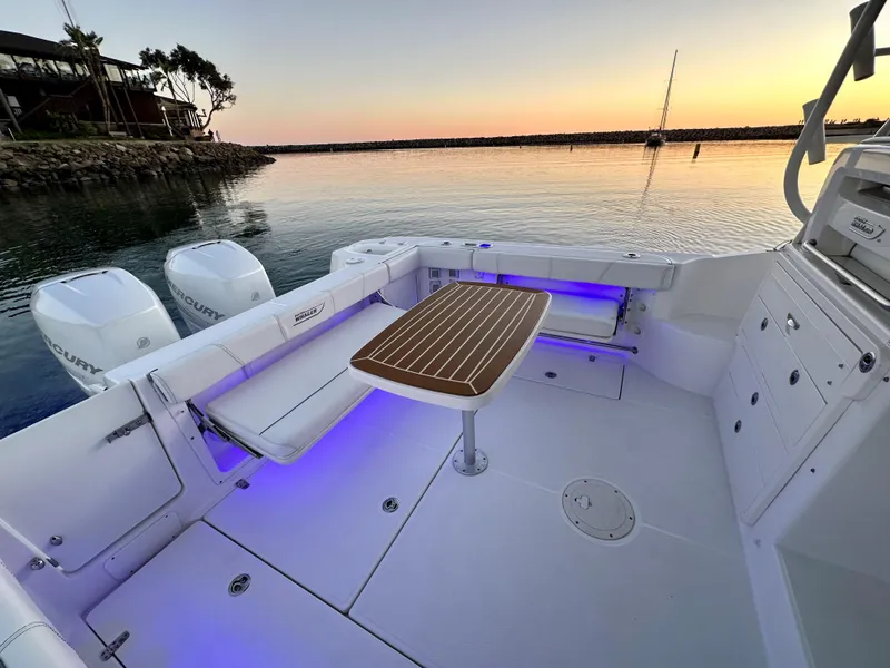 Slide: The Image of 2014 Boston Whaler 315 Conquest boat interior with table, sunset view. - 18