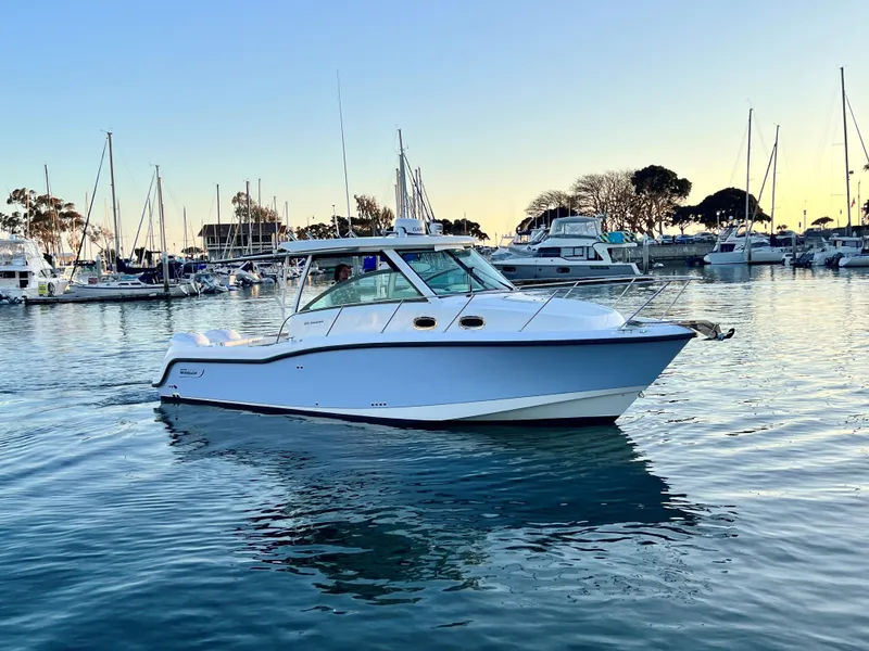 Slide: The Image of 2014 Boston Whaler 315 Conquest boat in a marina at sunset. - 2