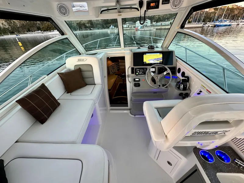 Slide: The Image of 2014 Boston Whaler 315 Conquest interior with helm, seating, and navigation equipment. - 22