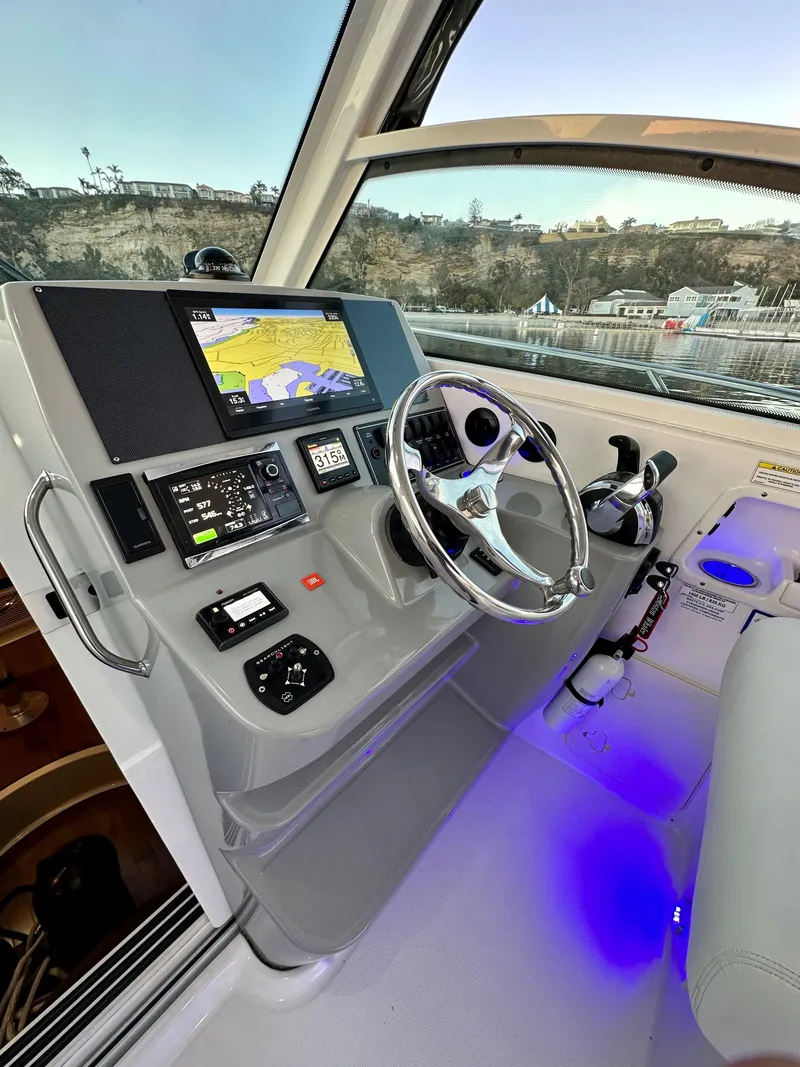 Slide: The Image of 2014 Boston Whaler 315 Conquest helm with navigation display and steering wheel. - 24