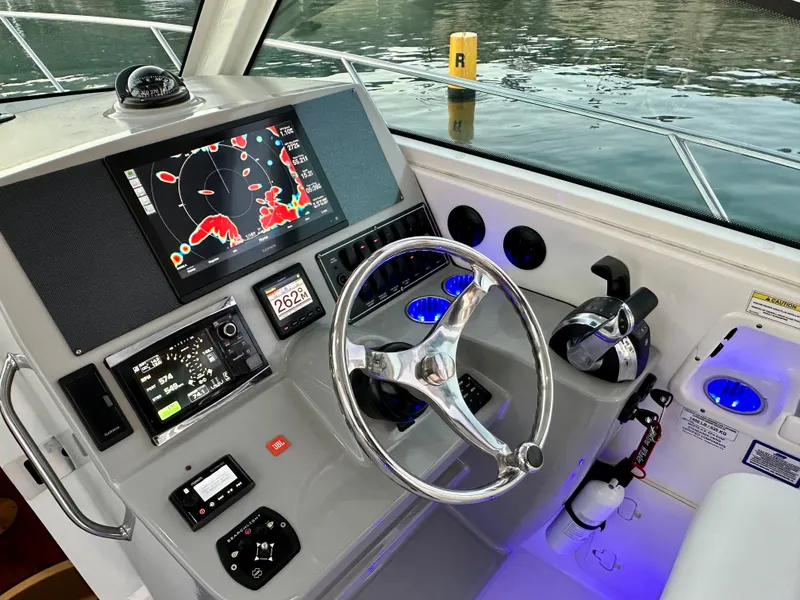 Slide: The Image of 2014 Boston Whaler 315 Conquest helm with navigation display and controls. - 25