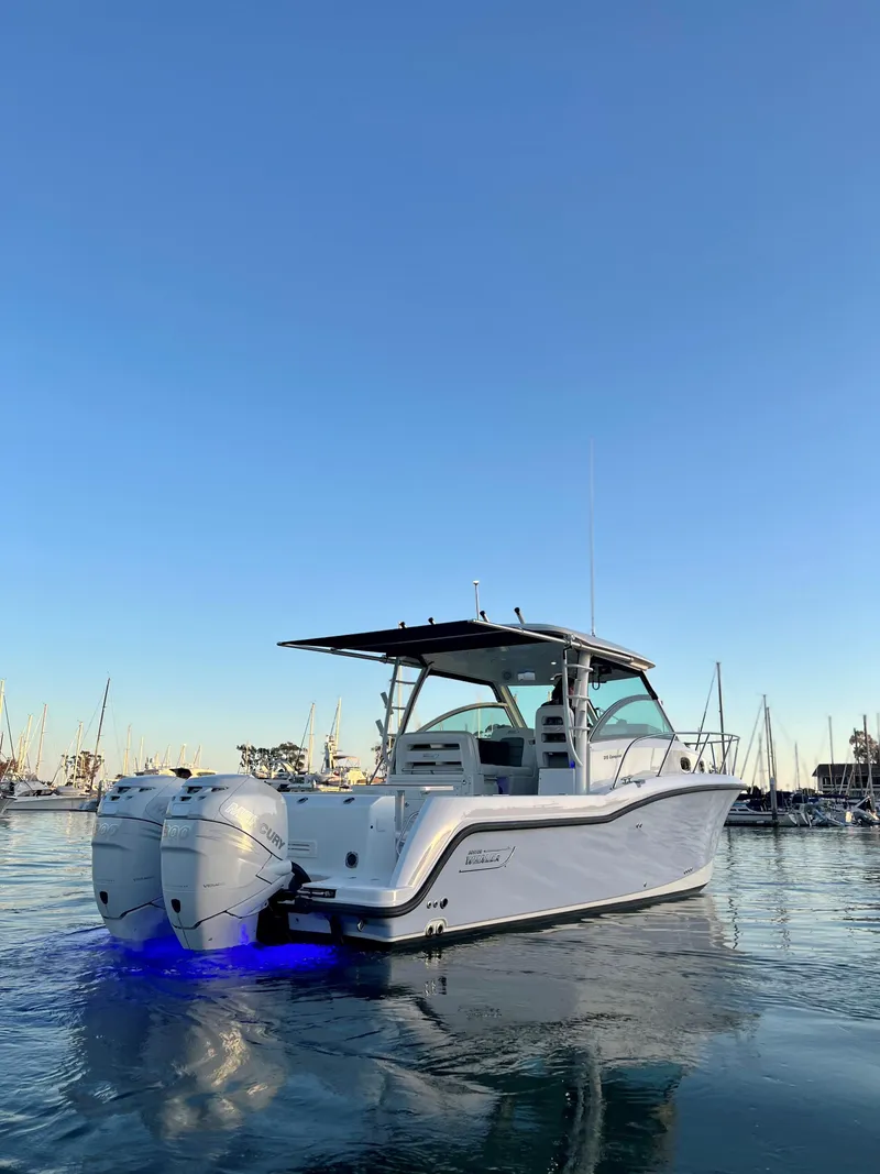 Slide: The Image of 2014 Boston Whaler 315 Conquest boat on calm water at sunset. - 6