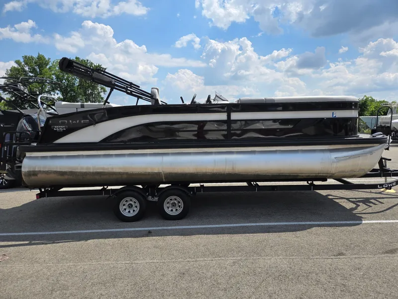 Slide: The Image of 2022 Lowe SS 230 CL pontoon boat on trailer under a blue sky. - 1