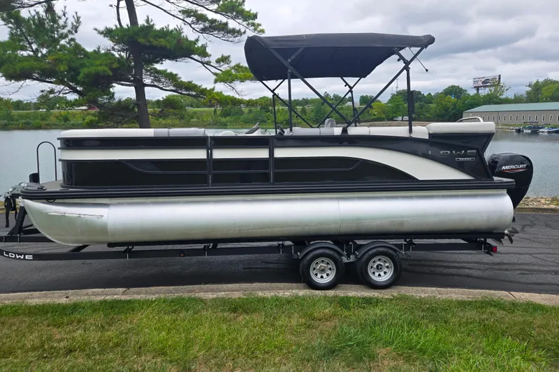 Slide: The Image of 2022 Lowe SS 230 CL pontoon boat on trailer by a lake. - 10