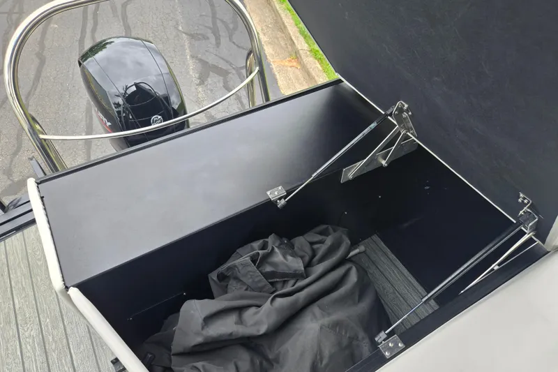Slide: The Image of Open storage compartment on 2022 Lowe SS 230 CL boat with Mercury engine visible. - 18