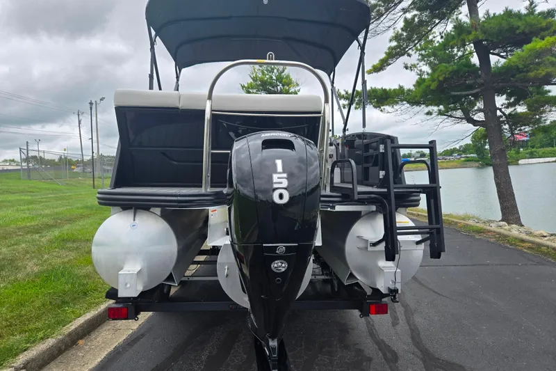 Slide: The Image of 2022 Lowe SS 230 CL pontoon boat with 150 HP Mercury engine, parked near a lake. - 3