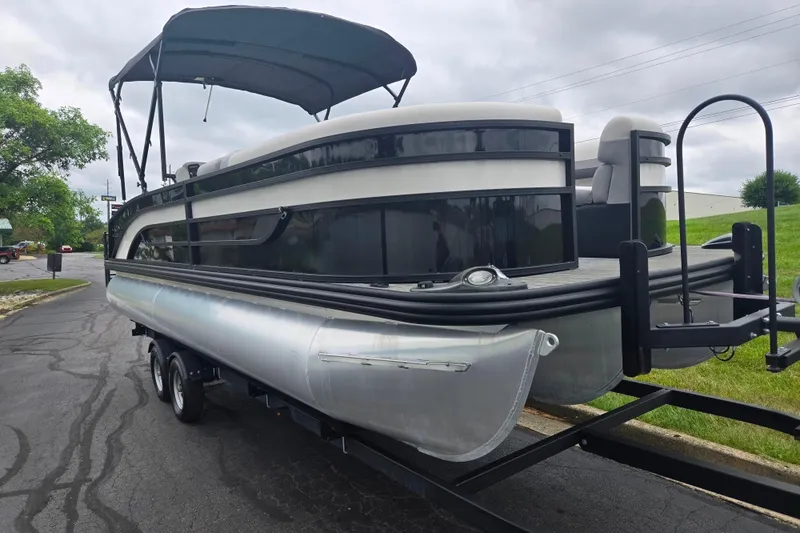 Slide: The Image of 2022 Lowe SS 230 CL pontoon boat on trailer, parked on a paved road. - 6