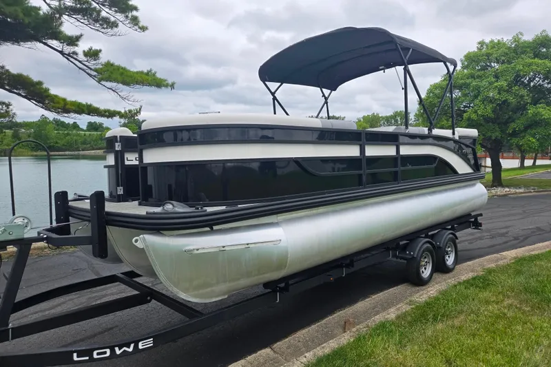 Slide: The Image of 2022 Lowe SS 230 CL pontoon boat on trailer by a lake. - 9