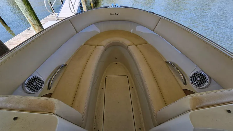Slide: The Image of 2013 Chris-Craft Launch 22 boat interior with beige seating and speakers, dockside view. - 11