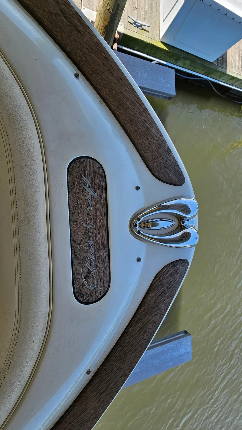 Slide: The Image of 2013 Chris-Craft Launch 22 boat with wood accents docked by the water. - 12