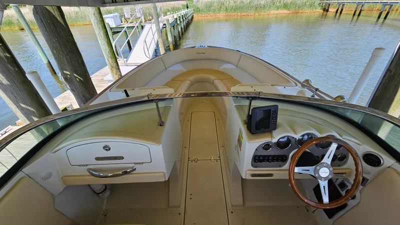 Slide: The Image of 2013 Chris-Craft Launch 22 boat interior with steering wheel and dashboard, docked by the water. - 4