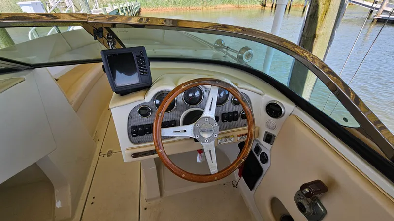 Slide: The Image of 2013 Chris-Craft Launch 22 boat dashboard with steering wheel and navigation equipment. - 5