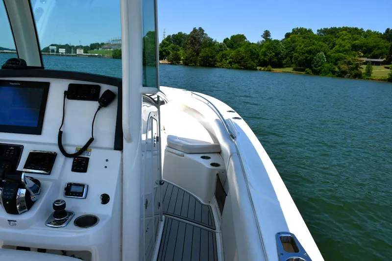 Slide: The Image of 2016 Boston Whaler 280 Outrage boat interior with white seating on a calm lake. - 22