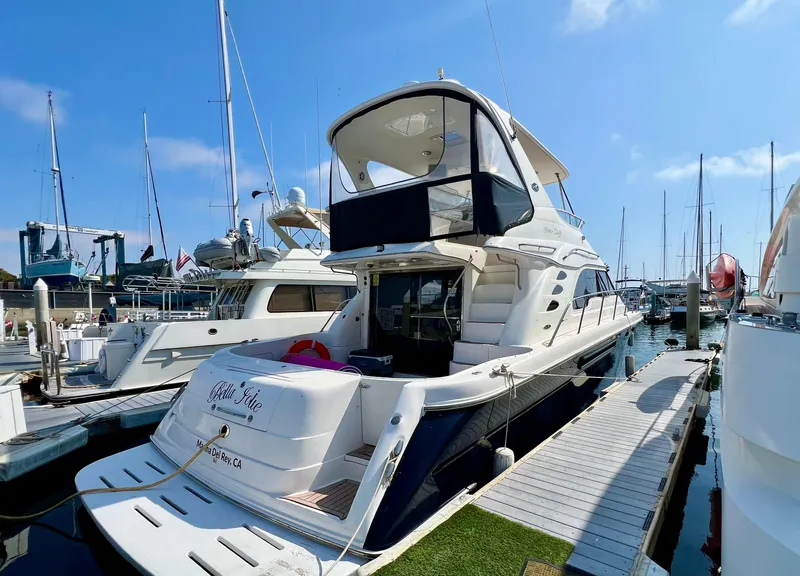 Slide: The Image of 2002 Sea Ray 560 Sedan Bridge yacht docked at marina under clear blue sky. - 10