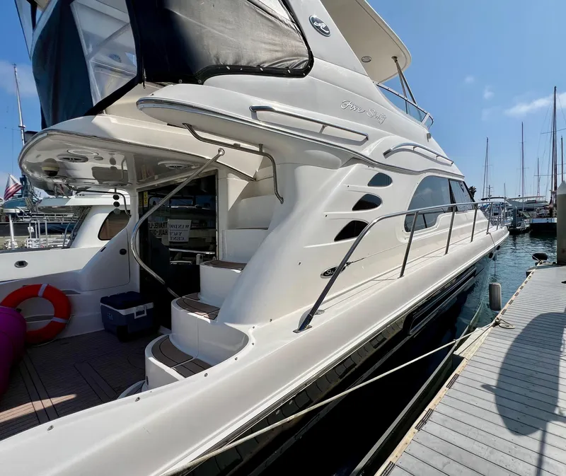 Slide: The Image of 2002 Sea Ray 560 Sedan Bridge yacht docked at marina, side view. - 11
