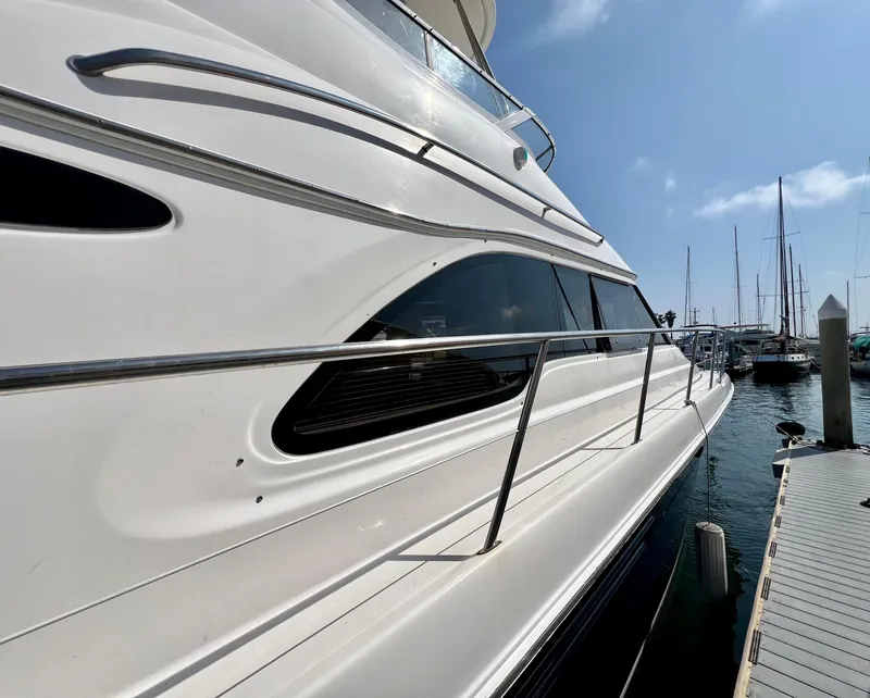 Slide: The Image of 2002 Sea Ray 560 Sedan Bridge yacht docked at marina, side view. - 12