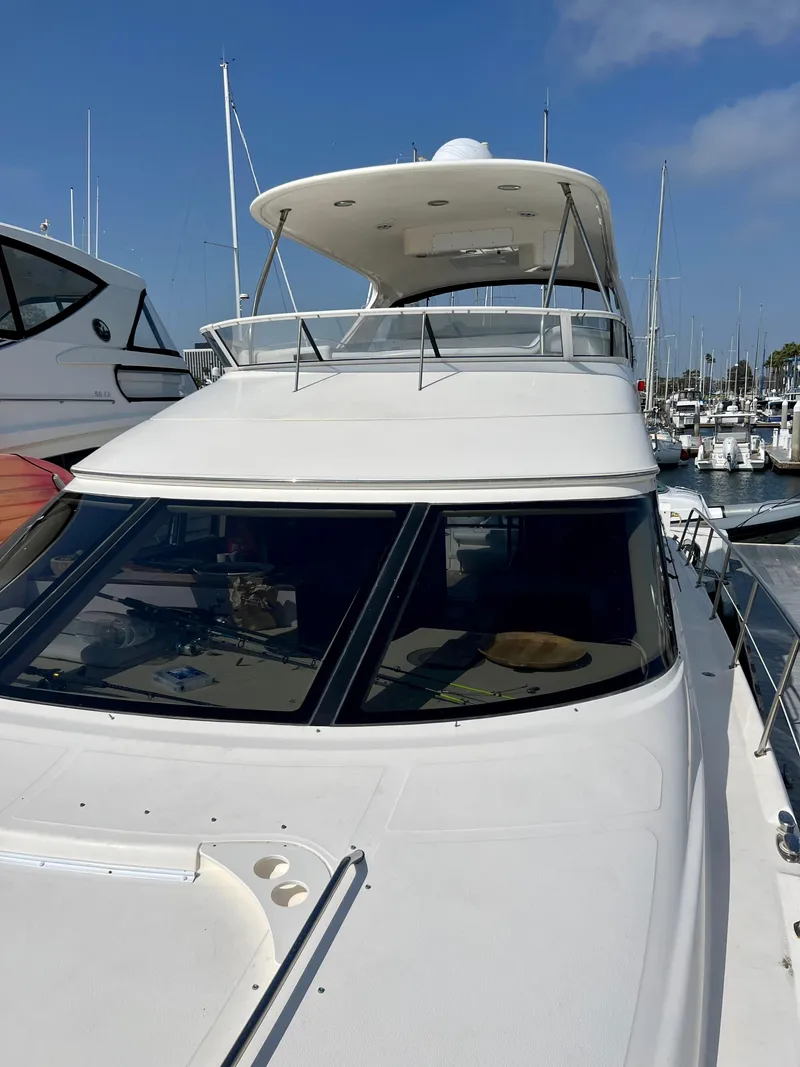 Slide: The Image of 2002 Sea Ray 560 Sedan Bridge yacht docked in marina under clear blue sky. - 16