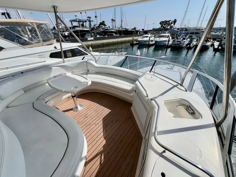 Slide: The Image of 2002 Sea Ray 560 Sedan Bridge yacht with spacious deck and marina view. - 24