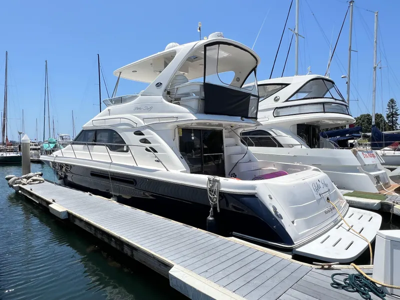 Slide: The Image of 2002 Sea Ray 560 Sedan Bridge yacht docked at marina under clear blue sky. - 4