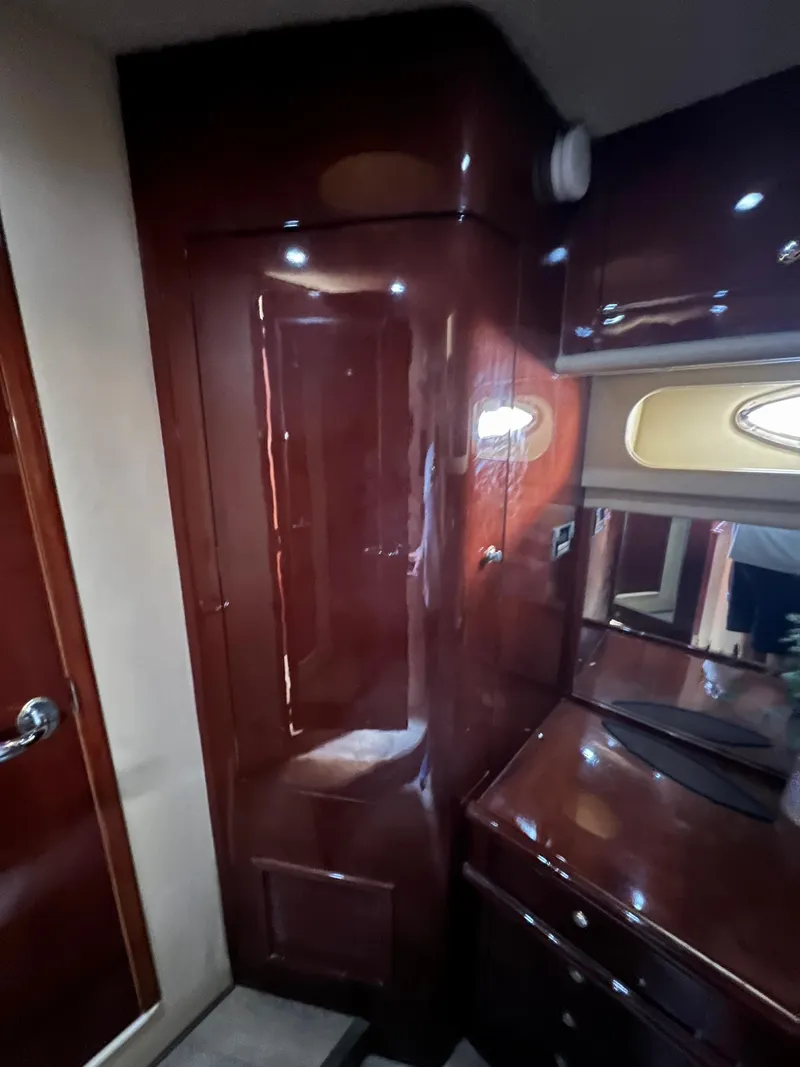 Slide: The Image of Interior of 2002 Sea Ray 560 Sedan Bridge with glossy wood finish and cabinetry. - 49