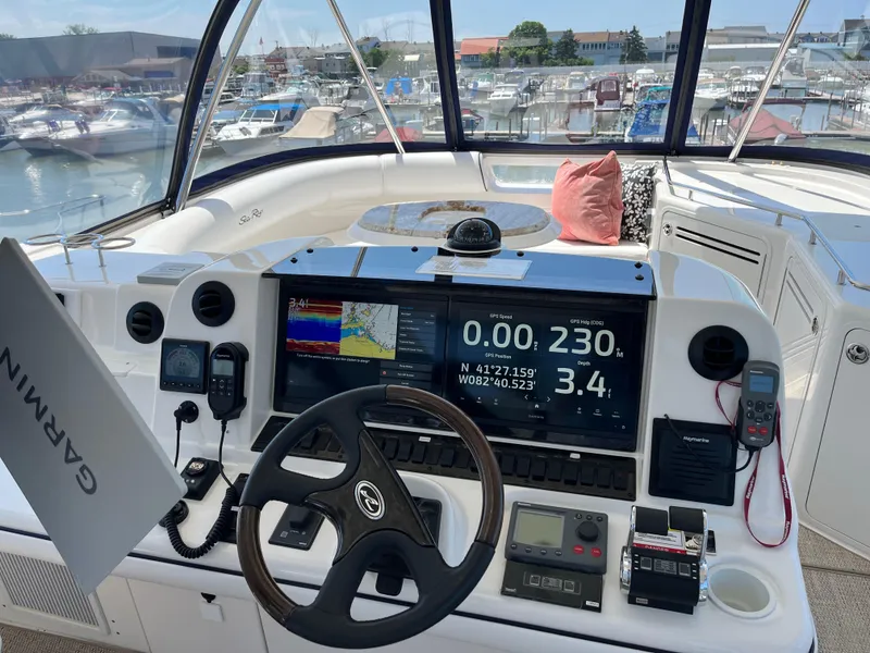 Slide: The Image of 2008 Sea Ray 58 Sedan helm with Garmin navigation, marina view, and modern controls. - 19